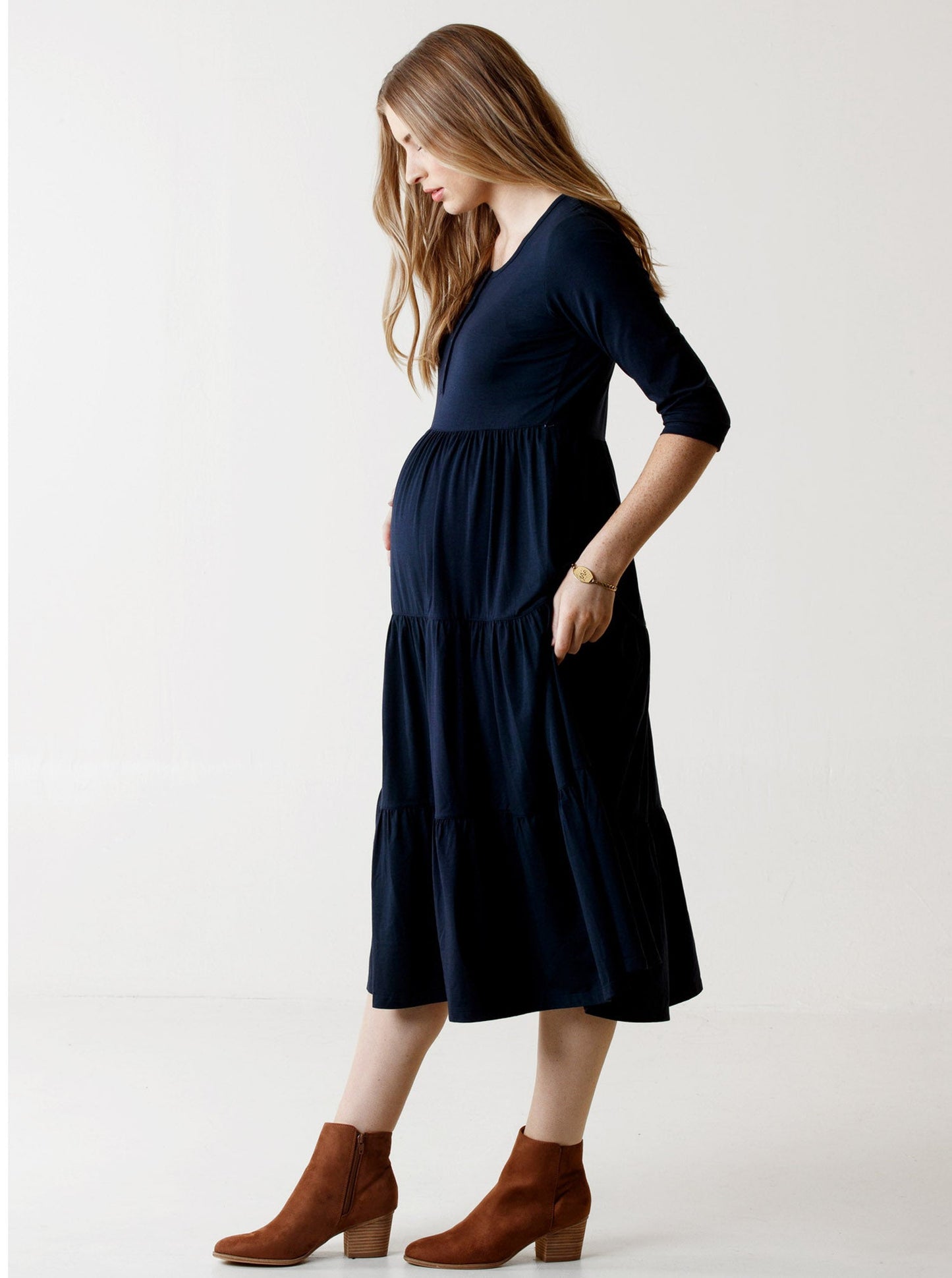 Side view - a woman in navy essential maternity tiered midi dress, side (6653086531687)